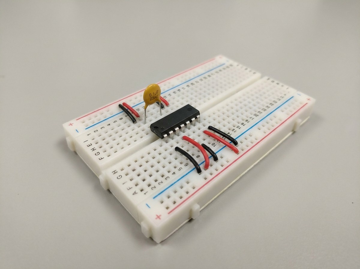 Close-up-photograph-of-a-solderless-breadboard-showing-proper-0.1-uF-ceramic-bypass-capacitor-placem.jpg